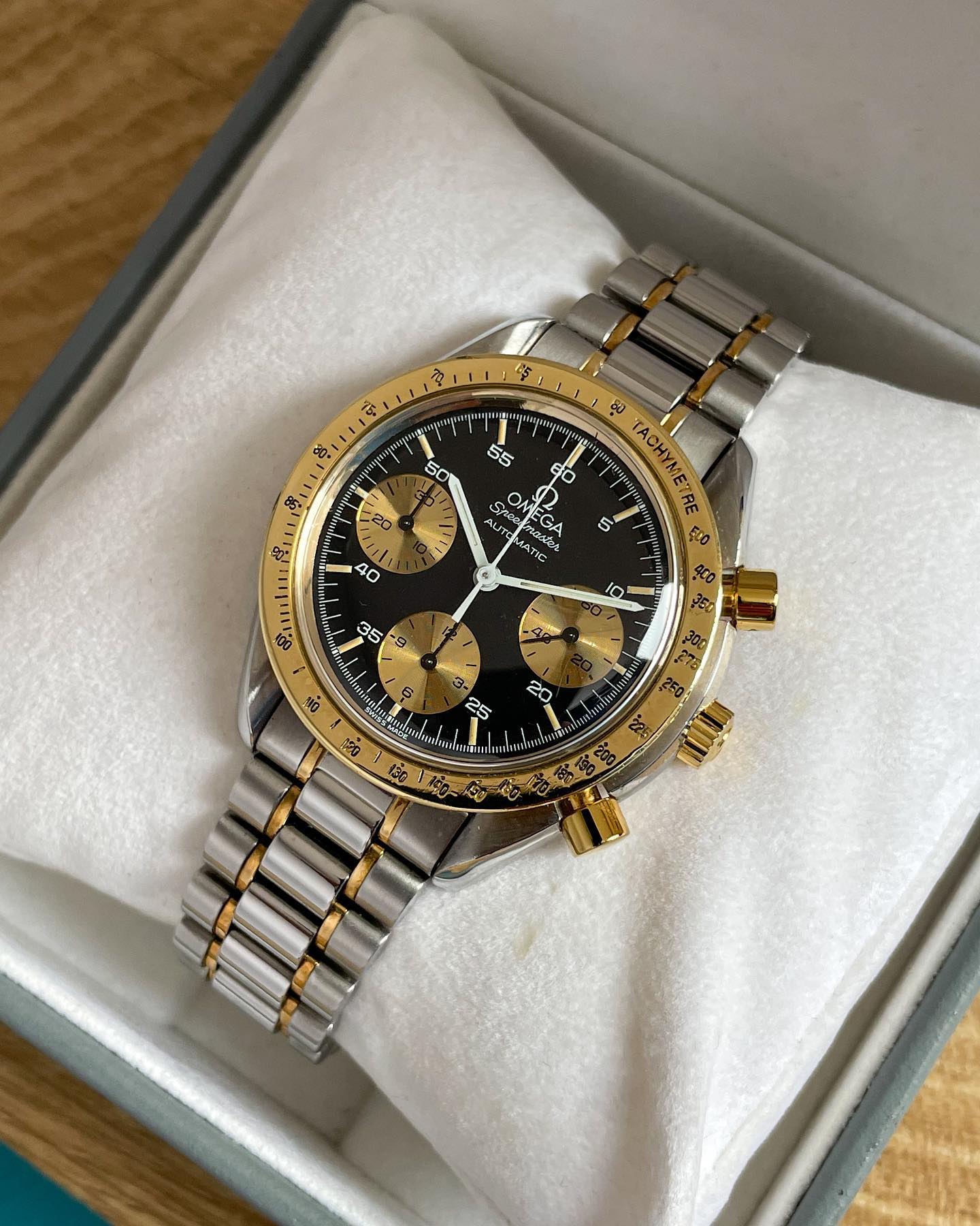 Black dial with golden bezel. Gold minute counter and chronograph subdials. Painted indices with 5 minute increments. White minute, hour and chronograph seconds hand. Subdials with black hands. Omega Speedmaster Reduced 175.0033