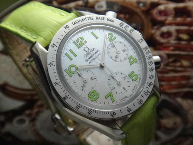 “Mother of Pearl” light dial with steel polished tachymètre bezel. Lime-green arabic numbers next to the hour indices. Silver hands. Omega Speedmaster Reduced 3834.72.35
