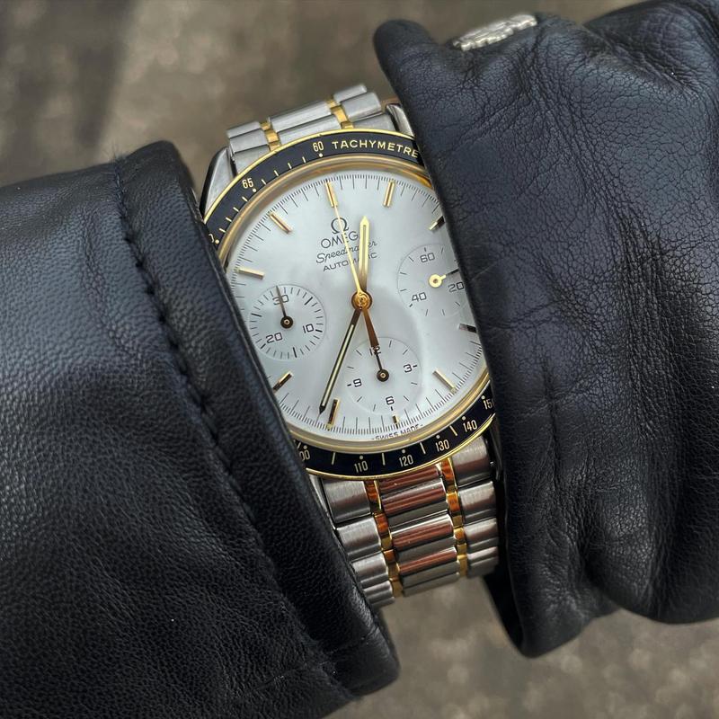White dial with golden bezel and a black tachymètre inlay. Golden applied indices and hands. Omega Speedmaster Reduced DA 375.0032